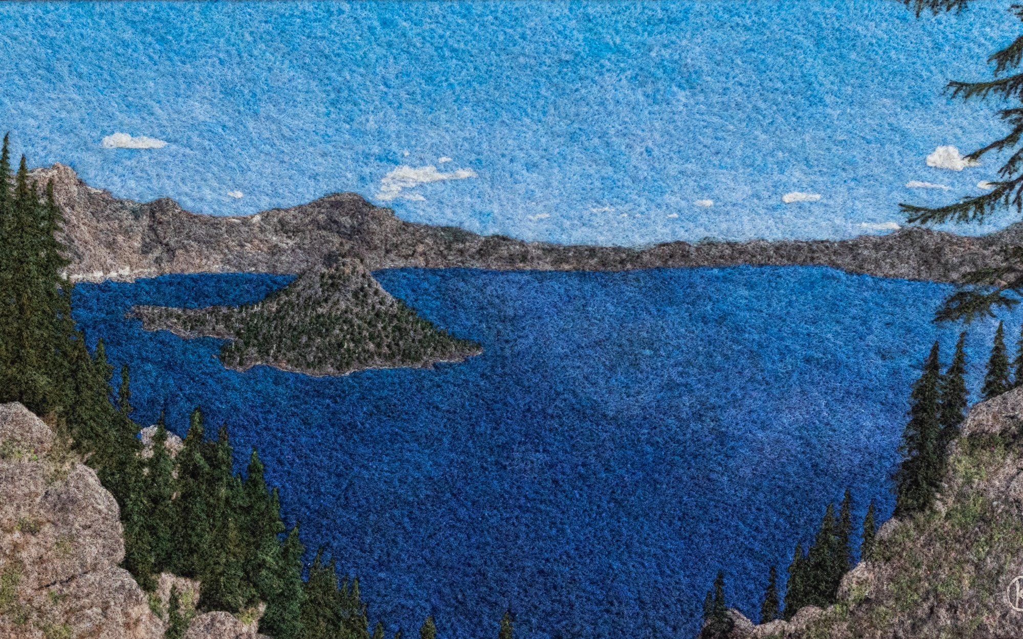 A two-dimensional felted wool landscape of a blue lake rimmed by mountains.